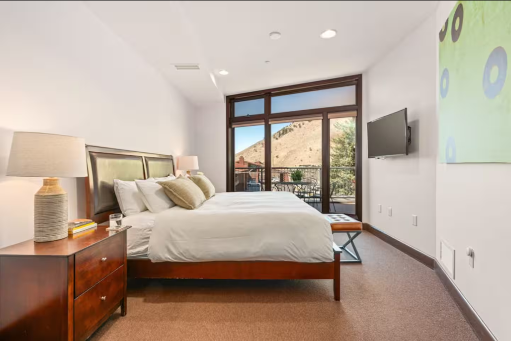 Primary bedroom with a private balcony and mountain views