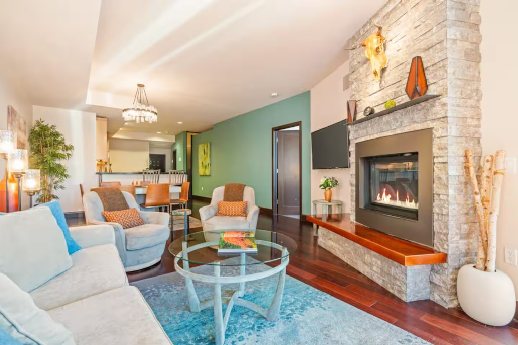 Lounge with a lit stacked-stone fireplace and mountain-modern furnishings